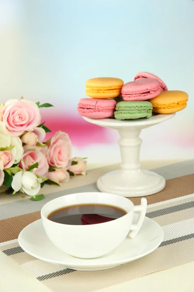 Kaffee und Makronen auf dem Tisch vor hellem Hintergrund — Stockfoto