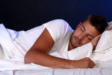 Yakışıklı genç adam yatakta.