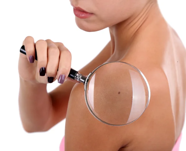 Beautiful girl sees skin through magnifying glass isolated on white — Stock Photo, Image