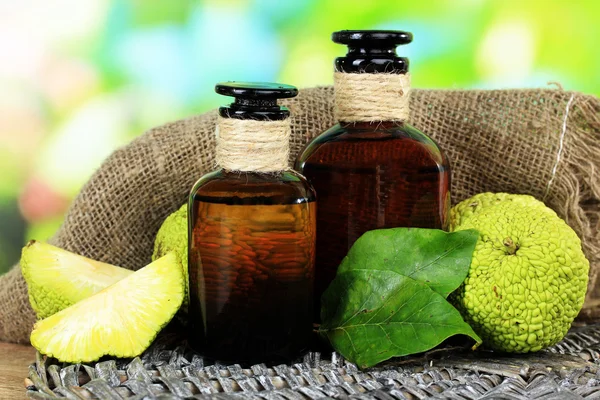 Osage oranje vruchten (maclura pomifera) en geneeskundeflessen, op houten tafel, op aard achtergrond — Stockfoto