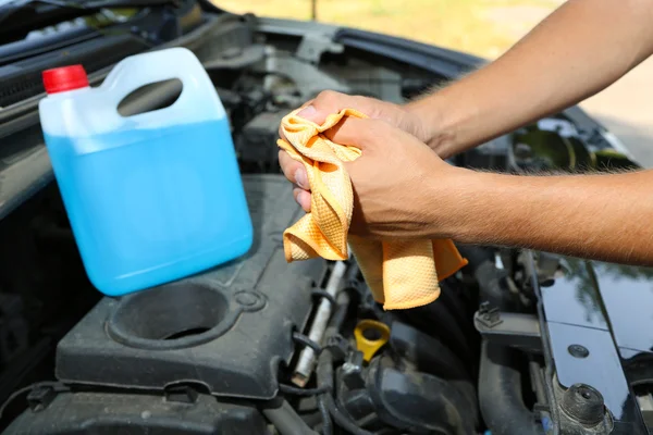 Mecánico de motor limpiando sus manos grasientas después de reparar el coche — Foto de Stock