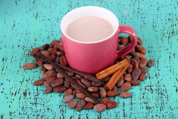 Cacao drank met specerijen en cacaobonen op houten achtergrond — Stockfoto