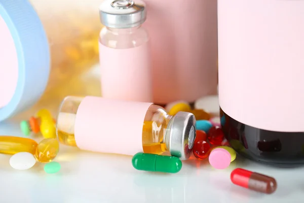 Tabletten und Medikamentenflaschen isoliert auf weiß — Stockfoto