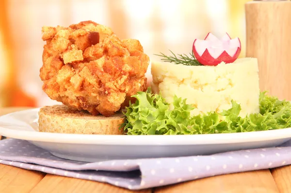 Chicken Kiev on croutons with mashed potatoes, on wooden table, on bright background — Stock Photo, Image