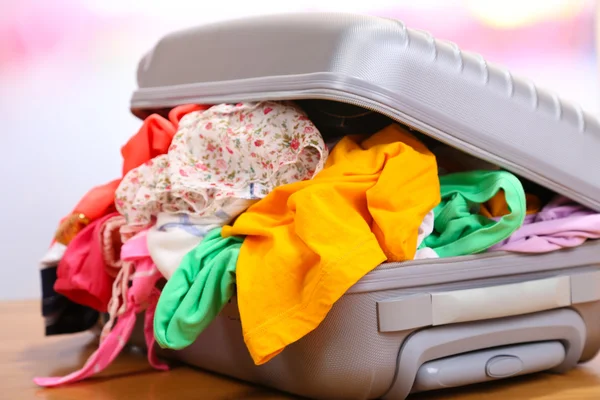 Suitcase with no neatly folded things on floor — Stock Photo, Image