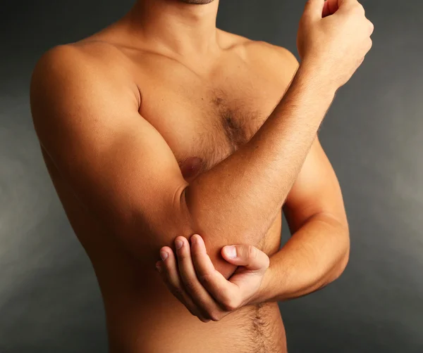 Young man with hand pain on grey background — Stock Photo, Image