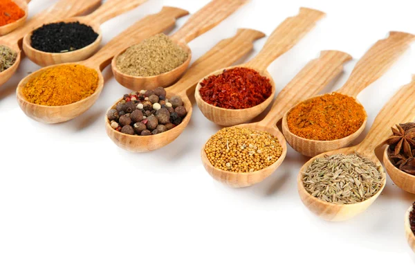 Assortment of spices in wooden spoons, isolated on white — Stock Photo, Image