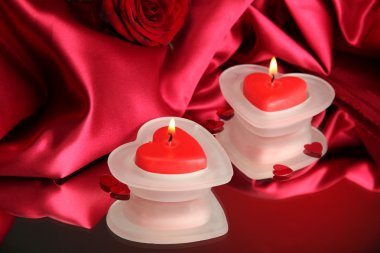 Güzel mumlar ve kırmızı ipek zemin üzerine gül