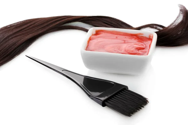 Tigela com tintura de cabelo e escova preta no fundo branco close-up — Fotografia de Stock