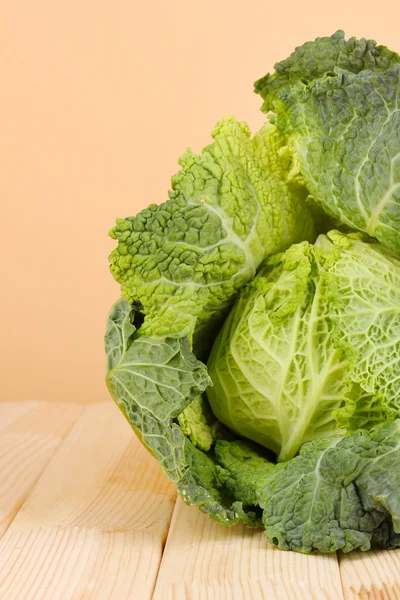 Fresh savoy cabbage on wooden table on beige background — Stock Photo, Image
