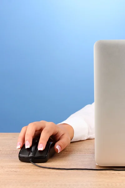 Τα χέρια της γυναίκας που πιέζει τα πλήκτρα του ποντικιού του υπολογιστή, σε μπλε φόντο κοντινό πλάνο — Φωτογραφία Αρχείου