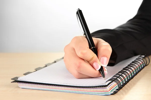 Mão escrever no caderno, no fundo branco — Fotografia de Stock