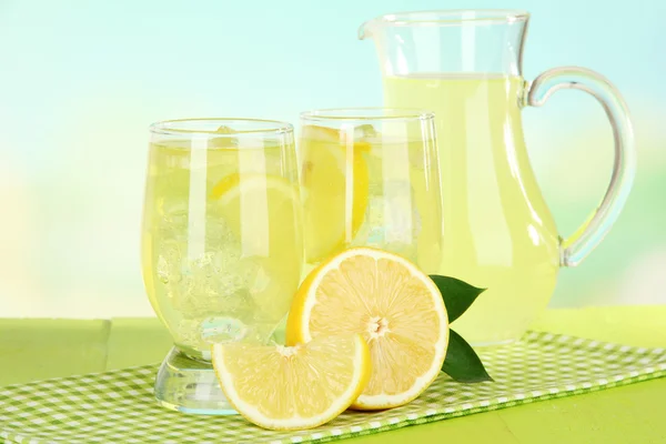 浅蓝色背景上的桌上美味柠檬水 — 图库照片