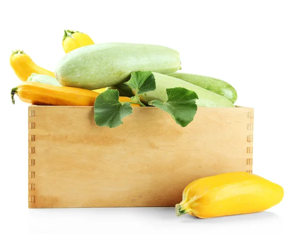 Raw yellow and green zucchini in wooden crate, isolated on white — Stock Photo, Image