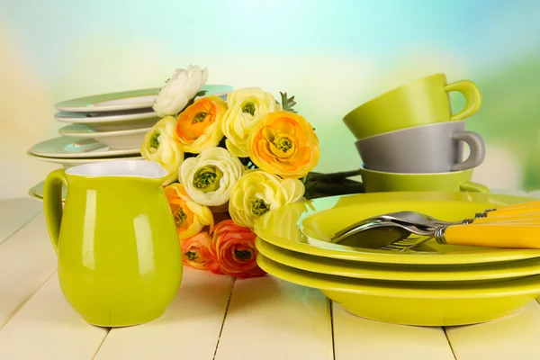 Lots beautiful dishes on wooden table on natural background — Stock Photo, Image