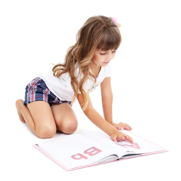 Menina sentada no chão com livro isolado em branco — Fotografia de Stock