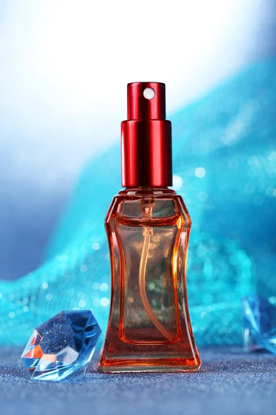 Frauen Parfüm in schönen Flasche auf blauem Hintergrund — Stockfoto