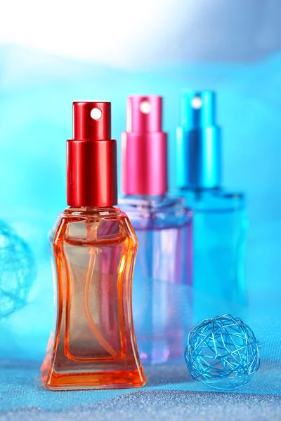 Жіночі парфуми в красивих пляшках на синьому фоні — стокове фото