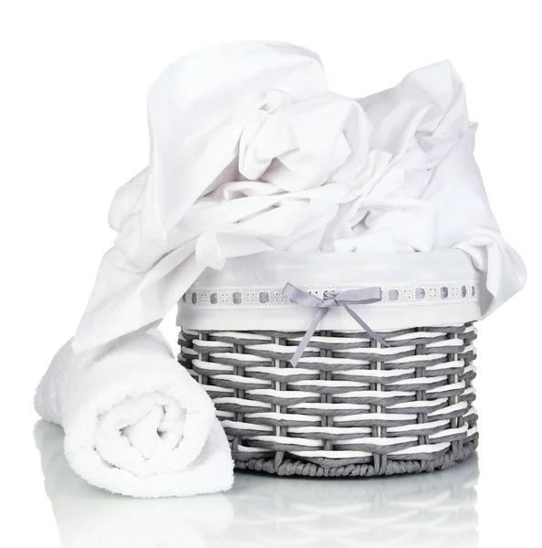 Rumpled bedding sheets in wicker basket isolated on white — Stock Photo, Image