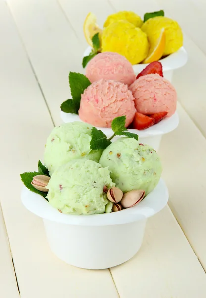 Вкусное мороженое в мисках, на деревянном столе — стоковое фото