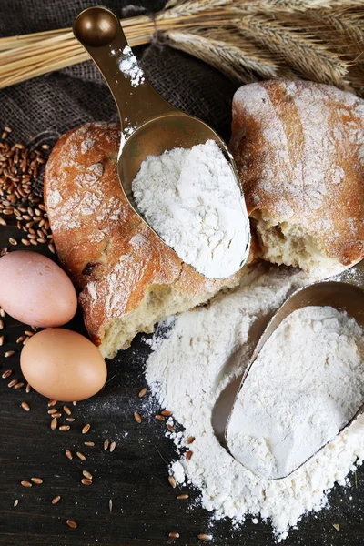 The wholemeal flour in scoops on wooden table — Stock Photo, Image