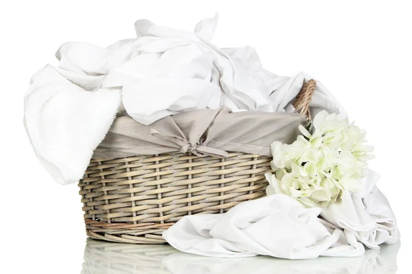 Rumpled bedding sheets in wicker basket isolated on white — Stock Photo, Image
