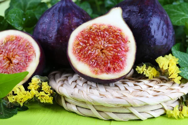 Ripe figs in leaves on wooden table close-up — Stock Photo, Image