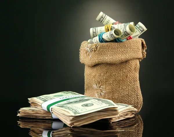 Dinero en bolsa sobre fondo de color oscuro — Foto de Stock