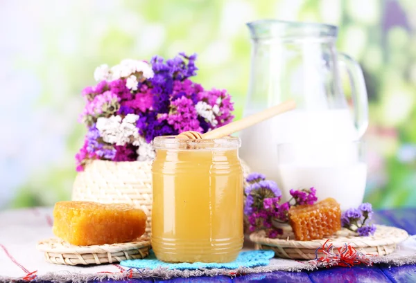 Miel y leche sobre mesa de madera sobre fondo natural —  Fotos de Stock