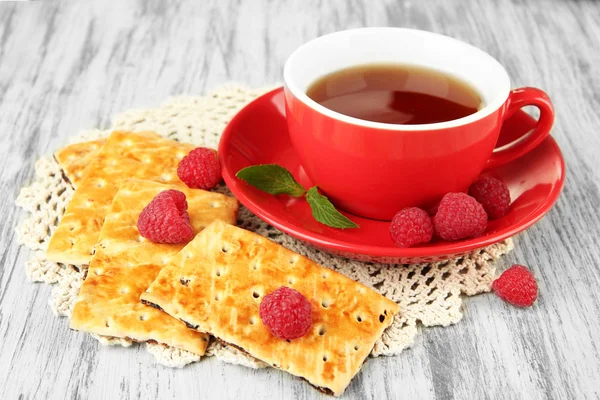 Taza de té con galletas y frambuesas en primer plano de la mesa —  Fotos de Stock