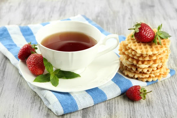 Taza de té con galletas y fresas en primer plano de la mesa — Foto de Stock