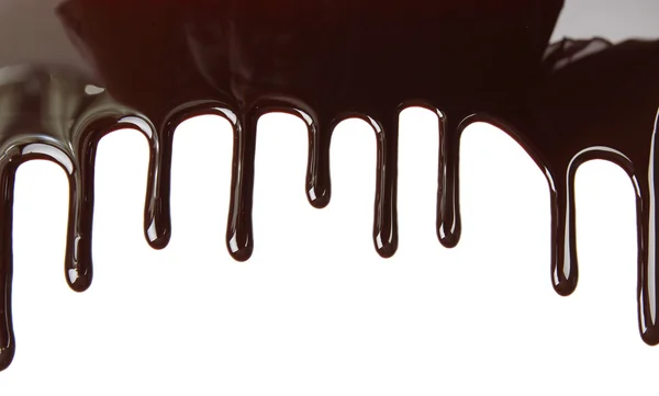 Melted chocolate dripping on white background — Stock Photo, Image