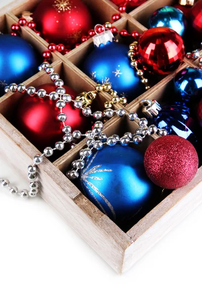 Рождественские игрушки в деревянной коробке, изолированные на белом — стоковое фото