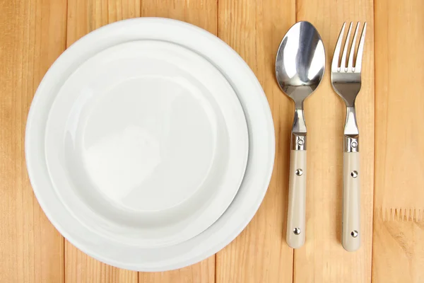 Plate and cutlery on wooden table close-up — Stockfoto