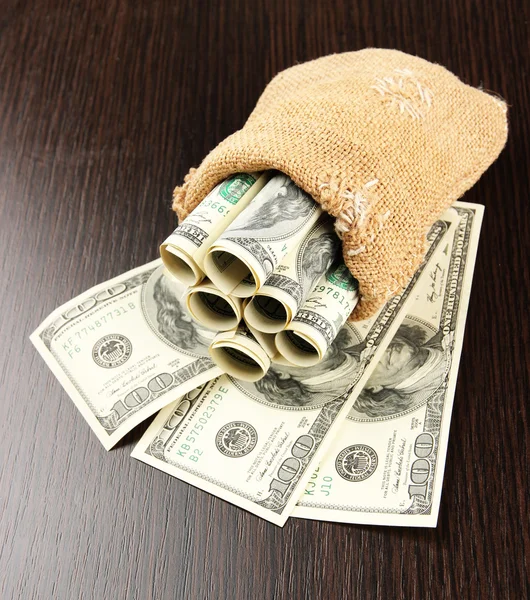 Geld in Tüte auf dunklem Hintergrund — Stockfoto