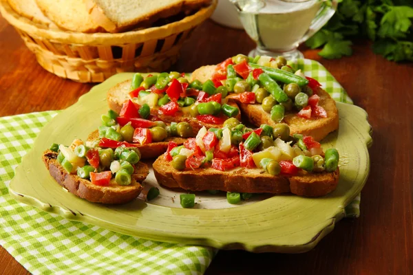 木製のテーブルのクローズ アップの皿の上の緑と野菜のサンドイッチ — ストック写真