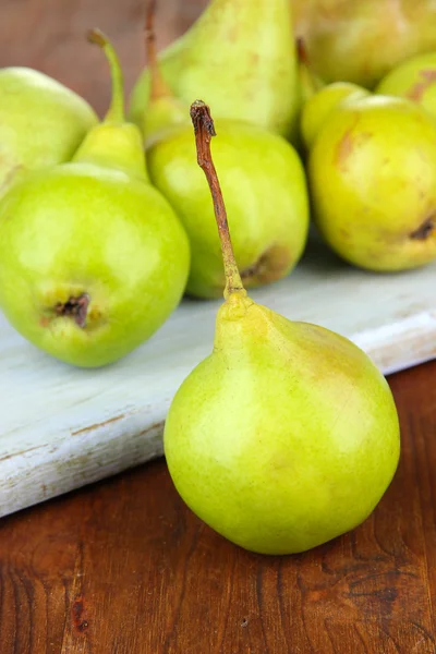 Pears on cutting board, on wooden background — Stock Photo, Image