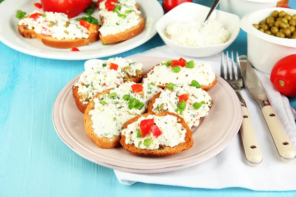 Sandwiches with cottage cheese and greens on plate on wooden table close-up — Stock Photo, Image