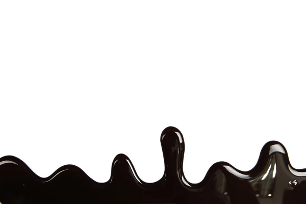 Geschmolzene Schokolade tropft auf weißem Hintergrund — Stockfoto