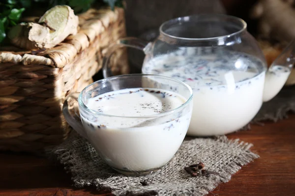ティーポットと牛乳と荒布明るい背景に木製のテーブルの香辛料とお茶のカップ — ストック写真