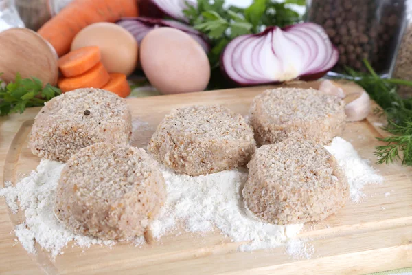 Meat patties on board on napkin — Stock Photo, Image