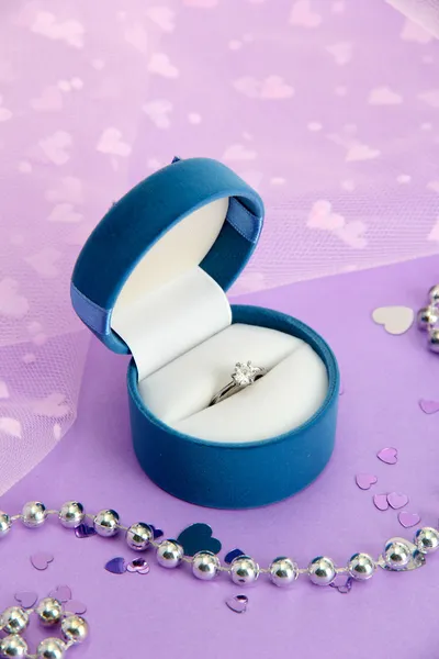 Belle boîte avec bague de mariage sur fond violet Images De Stock Libres De Droits