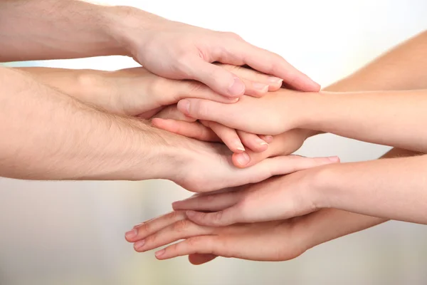 United hands on bright background. Conceptual photo of teamwork Stock Picture