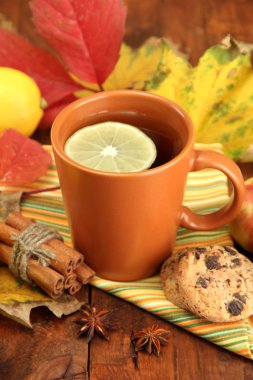 fincan sıcak çay ve ahşap masa üzerinde sonbahar yaprakları