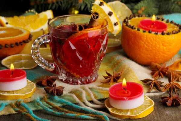 Fragrant mulled wine in glass with spices and oranges around on wooden table — Stock Photo, Image