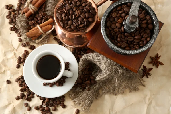 Filiżankę kawy, garnek i młynek na beżowym tle — Zdjęcie stockowe