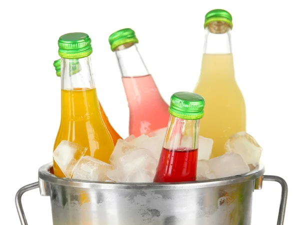 Botellas con sabrosas bebidas en cubo con cubitos de hielo, aisladas en blanco —  Fotos de Stock