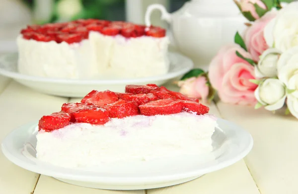 Cheesecake met verse aardbeien op witte plaat op houten tafel — Stockfoto