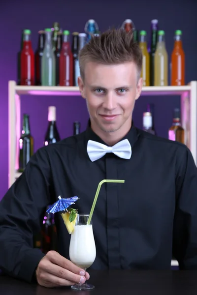 Portrait of handsome barman with Pina colada cocktail, at bar — Stock Photo, Image