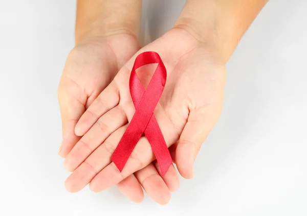 Лента СПИДа в руках, изолированных на белом — стоковое фото